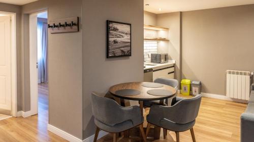 a kitchen and a table and chairs in a room at Alto Andino Hotel in Ushuaia