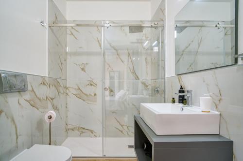 a bathroom with a sink and a toilet and a shower at Ella Suites Apartments in Terrasini