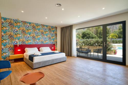 a bedroom with a bed and a large painting on the wall at Ella Suites Apartments in Terrasini