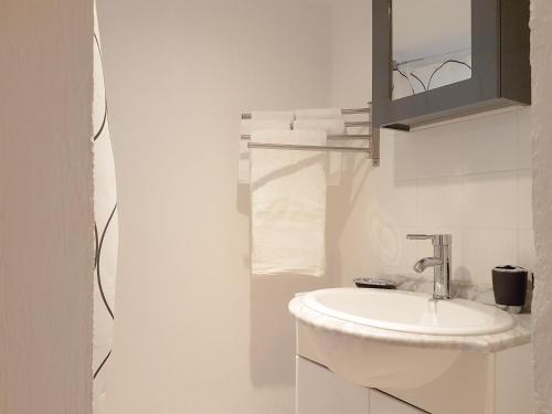 une salle de bain blanche avec un lavabo et un miroir dans l'établissement Le panier centre historique de marseille, à Marseille