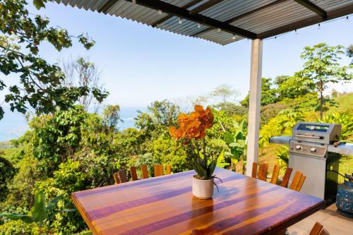 a wooden table with a vase of flowers on it at Canavida Villas & Resort in Uvita