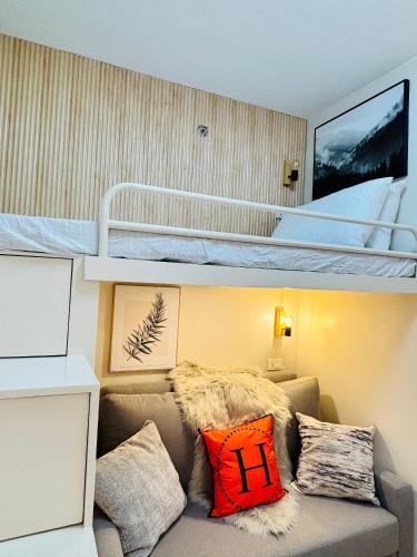 a living room with a couch and bunk beds at Comfortable Classy Combined - Amazing Unit Just Around the Block in Iloilo City