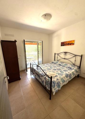 a bedroom with a bed and a door to a balcony at Brigida's Apartments in Ipsos