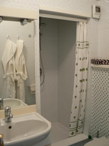 a bathroom with a sink and a shower curtain at Maison Bibian in Aosta