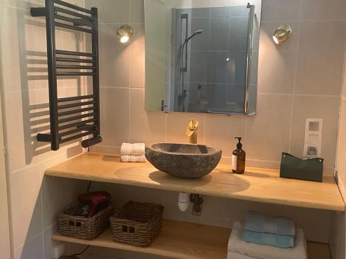 une salle de bain avec un lavabo en pierre et un miroir dans l'établissement Au milieu des bois, à Saint-Sauveur