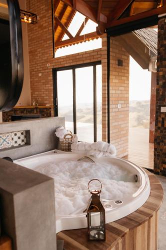 a large bath tub in a room with a window at Chalé Além do Horizonte in Bom Repouso