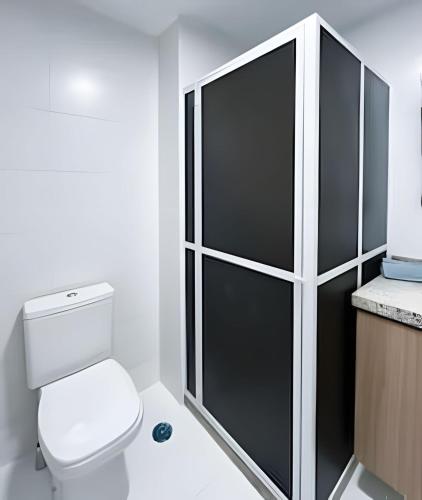a bathroom with a toilet and a black and white cabinet at Aptos Imperdíveis com Piscina Aquecida 2204 e 2304 in Rio de Janeiro