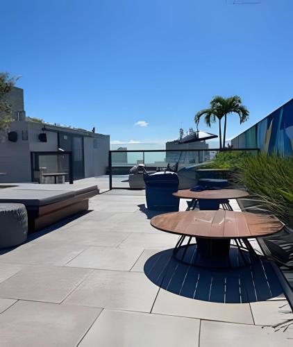 a patio with tables and the ocean in the background at Aptos Imperdíveis com Piscina Aquecida 2204 e 2304 in Rio de Janeiro