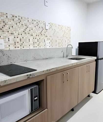a kitchen with a sink and a microwave at Aptos Imperdíveis com Piscina Aquecida 2204 e 2304 in Rio de Janeiro