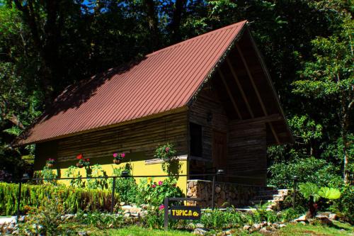 a small wooden building with a red roof at TREE TREK BOQUETE Adventure Park in Boquete