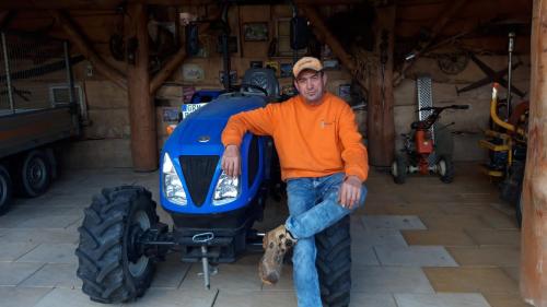 a man sitting on the front of a tractor at Pension Ronnys wilde Wiese in Belgershain