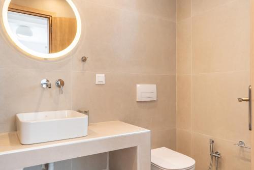 a bathroom with a white sink and a mirror at CrossRhodes Villas in Pefki Rhodes