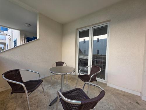 a table and chairs in a room with a window at Blue Dream Apartment in Rafailovici