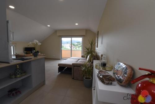 a kitchen and living room with a couch and a table at House Vila Santa Ana in Santana