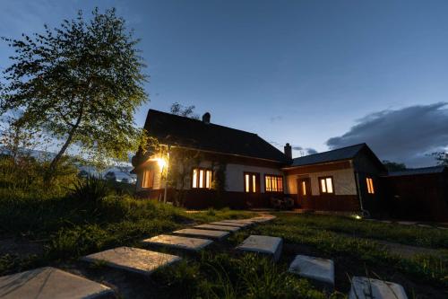 a house with the lights on at night at Trei Lumi in Deleni