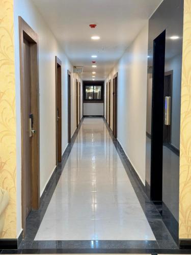 a corridor in a building with white walls and a long hallway at Hotel Deccan Park in Haidar Sāhibgūda