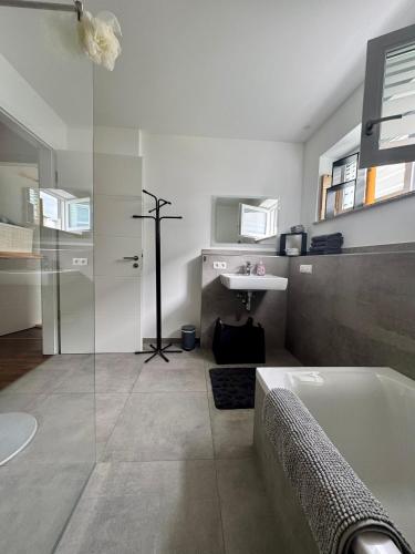 a bathroom with a bath tub and a sink at Moderne Wohnung 100 m2 mit Büro und Terrasse in Mühldorf
