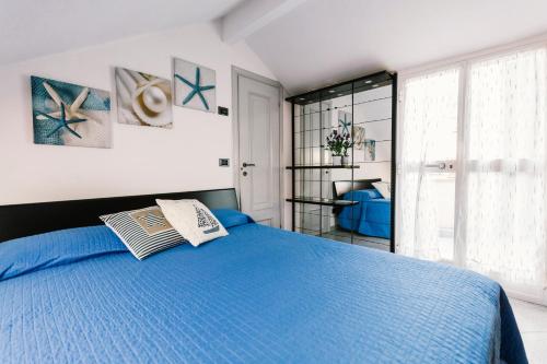 a bedroom with a blue bed and a window at Terrazza d'Amare - Alassio Centro in Alassio