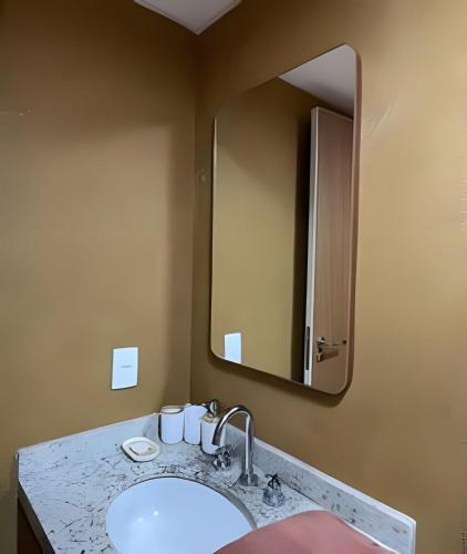 a bathroom with a sink and a mirror at LUXO 1603 Melhor Custo com Piscina Aquecida e WIFI in Rio de Janeiro