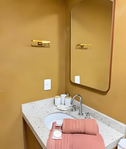 a bathroom with a sink and a mirror at LUXO 1603 Melhor Custo com Piscina Aquecida e WIFI in Rio de Janeiro