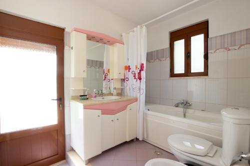 a bathroom with a toilet and a tub and a sink at Doel's Villa in Gjirokastër
