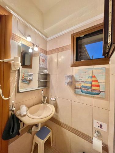 a small bathroom with a sink and a window at Palamidi in Agia Paraskevi
