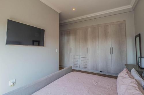 a bedroom with a bed and a tv on the wall at Views at Schoeman in Sandton