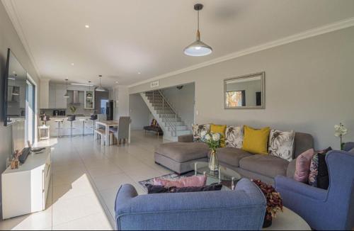 a living room with couches and a dining room and a kitchen at Views at Schoeman in Sandton