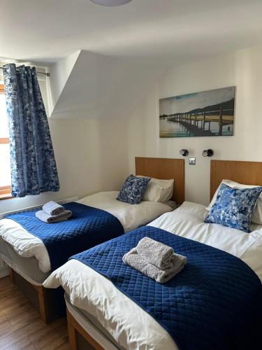 a bedroom with two beds with blue and white sheets at Ulster Cottages 4 miles From Portrush Bushmills Coleraine and Ballymoney in Bushmills