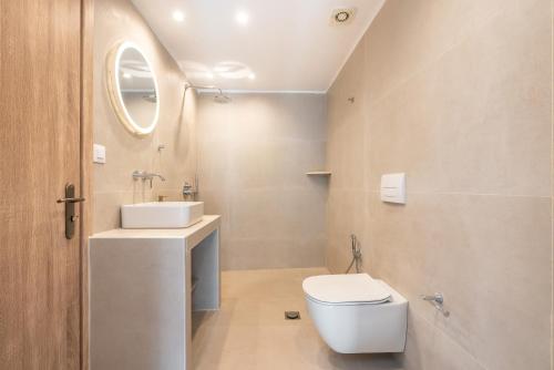 a bathroom with a white toilet and a sink at CrossRhodes Villas in Pefki Rhodes