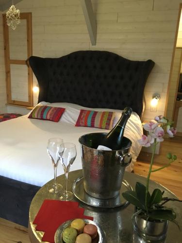 - un lit avec une table, une bouteille de vin et des verres dans l'établissement Cabane Perchée Spa Dordogne La Ferme de Sirguet, à Monsac