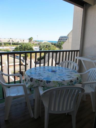 une table et des chaises sur un balcon avec vue dans l'établissement Studio F32 Héliopolis - 2 personnes, au Cap d'Agde