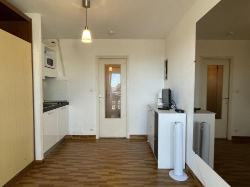 une cuisine avec un réfrigérateur et un micro-ondes dans l'établissement Studio F32 Héliopolis - 2 personnes, au Cap d'Agde