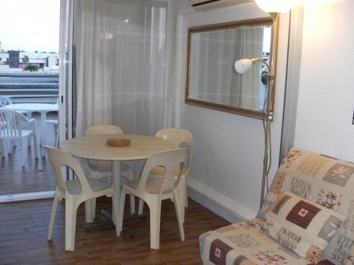 - un salon avec une table et des chaises dans l'établissement Héliopolis Studio F28 - 4 personnes, au Cap d'Agde