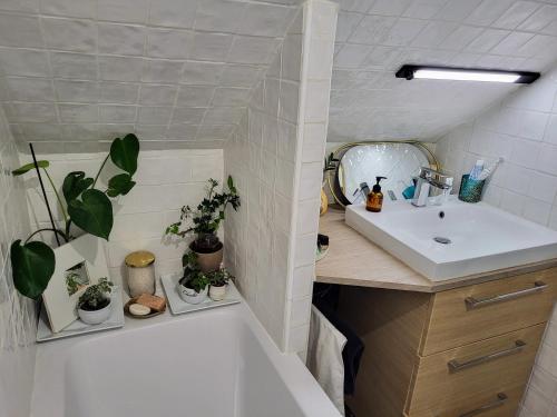 La salle de bains est pourvue d'une baignoire blanche, d'un lavabo et d'une baignoire. dans l'établissement Martyrs 