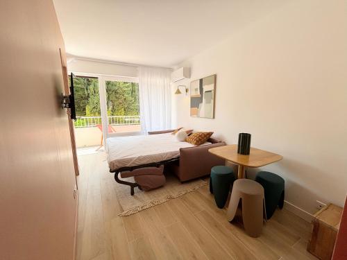 une petite chambre avec un lit et une table dans l'établissement Proche Palais Des Festivals, plage 5min - Palmazur Vacances, à Cannes