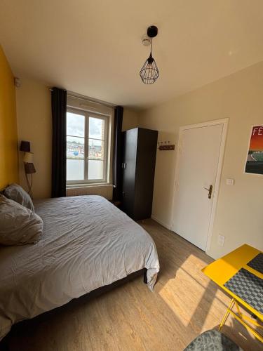 une chambre avec un lit, une fenêtre et un bureau dans l'établissement La Rose Des Vents, à Fécamp