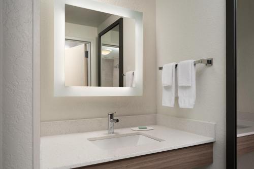 a bathroom with a sink and a mirror at SpringHill Suites Fort Myers Airport in Fort Myers