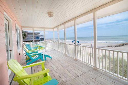 a porch with rocking chairs and the beach at Barefoot Bungalow in Edisto Island