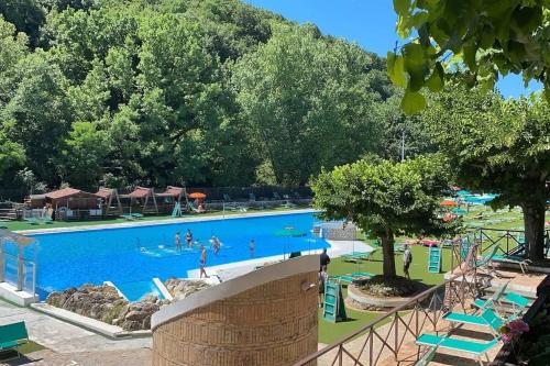 a large swimming pool with people playing in it at La casa di Belle in Castelchiodato