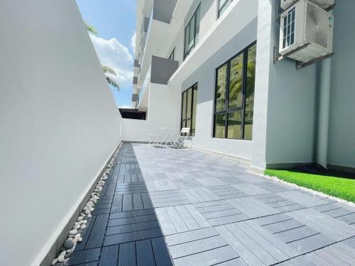 a hallway of a white building with a patio at Up to 6 Pax, Next to Paradigm mall JB with Big Patio & Pool Access in Johor Bahru