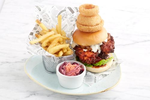 a plate of food with a chicken sandwich and french fries at Holiday Inn Runcorn M56 Junction 12 by IHG in Runcorn