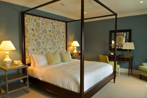 1 dormitorio con cama con dosel y escritorio en The Quogue Club, en Quogue