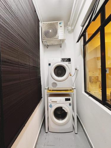 a laundry room with a washing machine and a window at Up to 6 Pax, Next to Paradigm mall JB with Big Patio & Pool Access in Johor Bahru