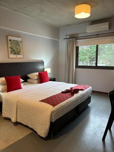 a bedroom with a large bed with red pillows at Pilar Suites by Viva in Pilar