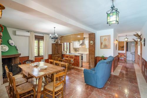 a dining room and living room with a table and chairs at Casa Rural Molino Macegal new in Carcabuey