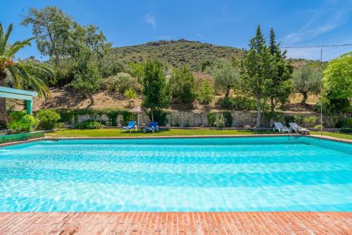 a swimming pool with a mountain in the background at Casa Rural Molino Macegal new in Carcabuey