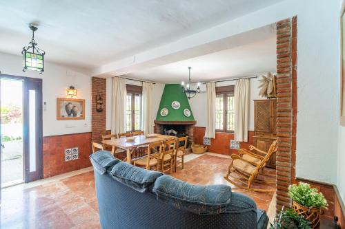 a living room with a table and a fireplace at Casa Rural Molino Macegal new in Carcabuey