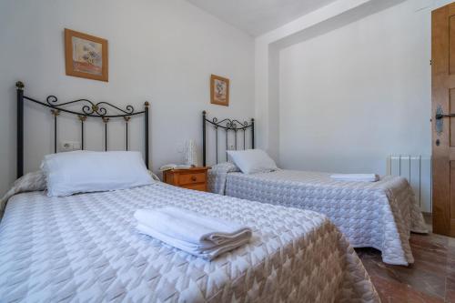a bedroom with two beds with towels on them at Casa Rural Molino Macegal new in Carcabuey