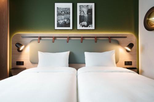 two beds in a room with green walls at Campanile Paris Ouest - Pont de Suresnes in Suresnes